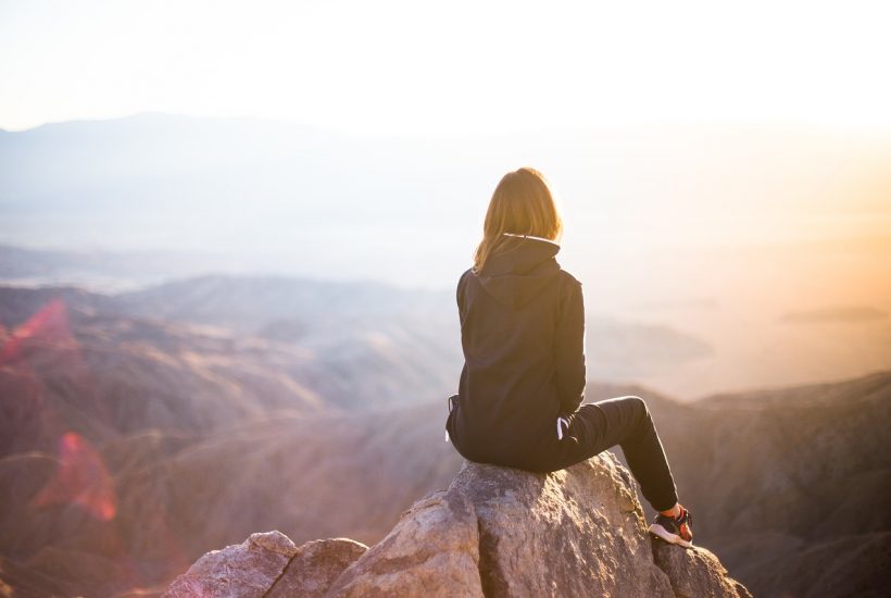 Woman sitting on cliff