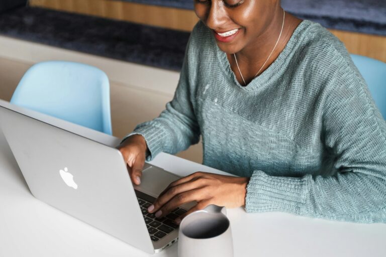 woman smiling as she looks at her computer
